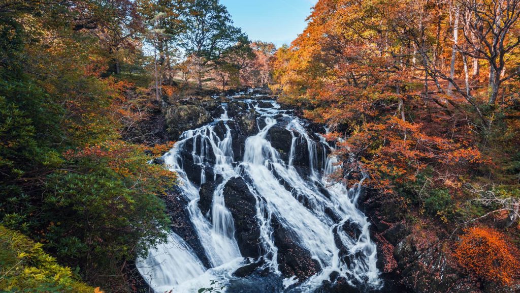 waterfall over the mountain with autumnal